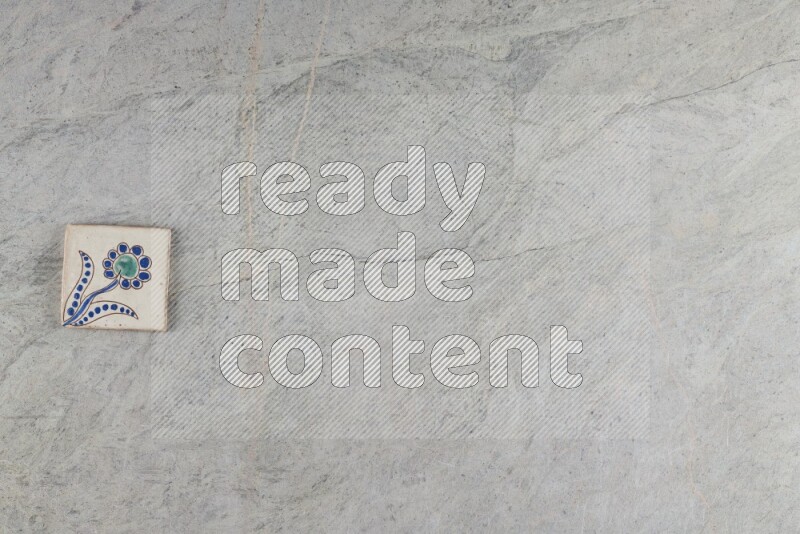 A decorative pottery coaster on grey marble background
