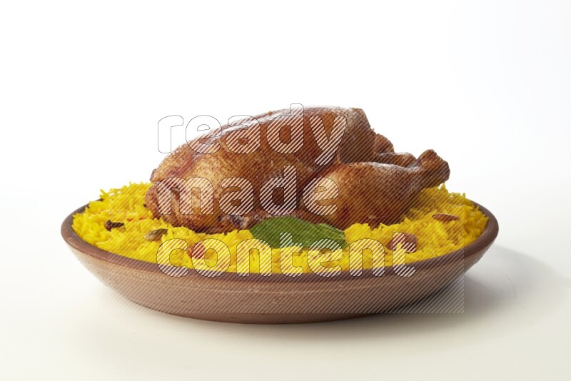 yellow basmati Rice with whole roasted chicken  on a pottery plate  direct  on white background