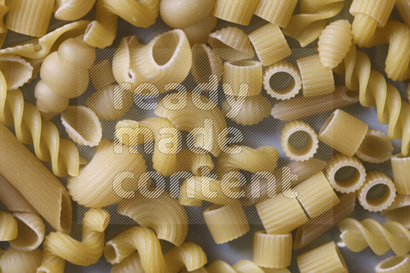Different pasta types on light blue background