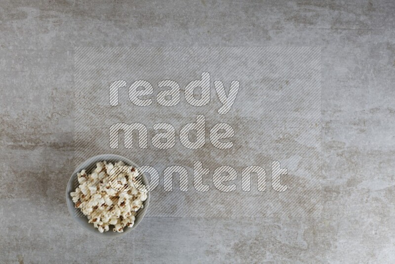 popcorn in gray bowl on a grey textured countertop