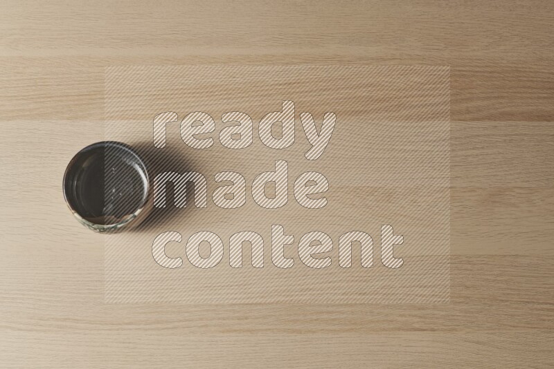 A multicolored pottery bowl on light wooden background