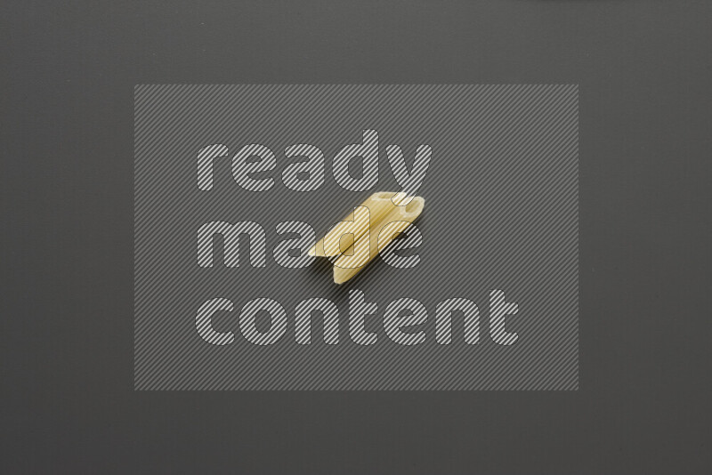 Mini penne pasta on grey background