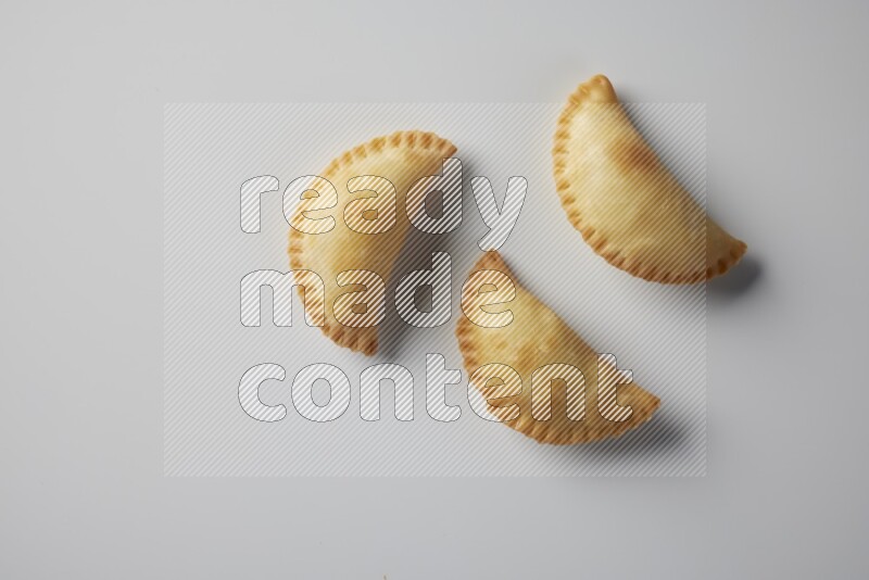 Three fried sambosa from a top angle on a white background