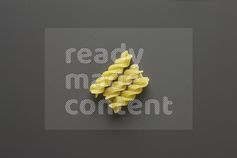 Fusilli pasta on grey background