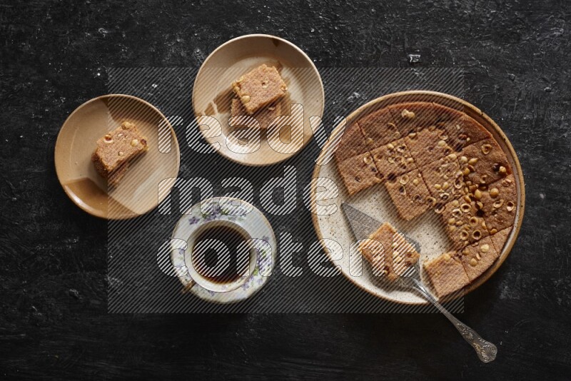 Basbousa with tea in a dark setup
