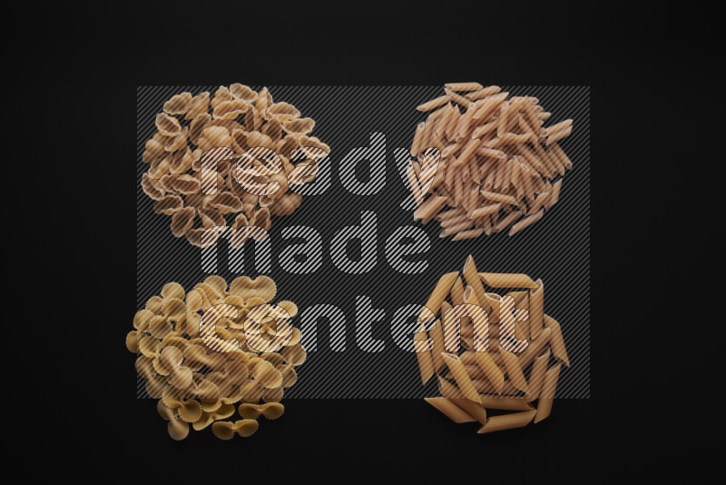 Different pasta types in bunches on black background