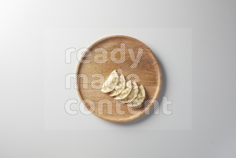 Five Sambosas on a wooden round plate on a white background