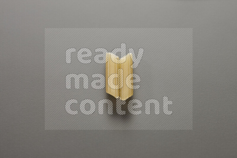 Mini penne pasta on grey background