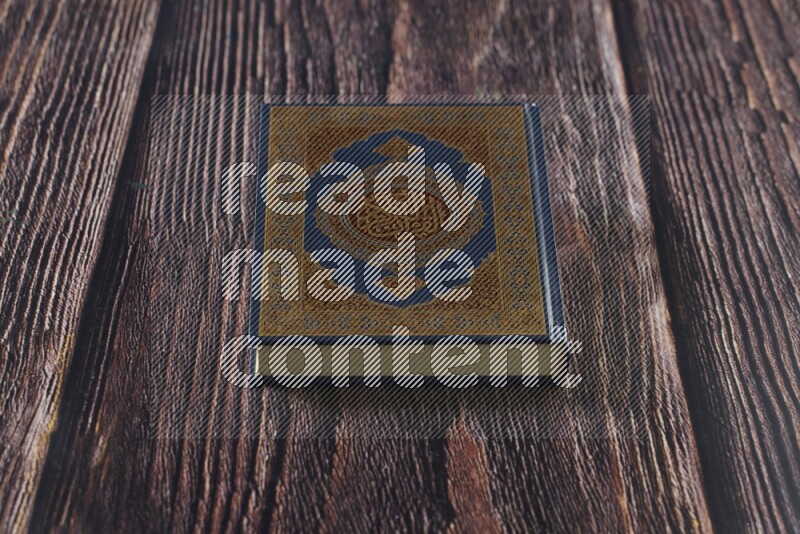 مصحف مع سبحة صلاه علي خلفية خشبية