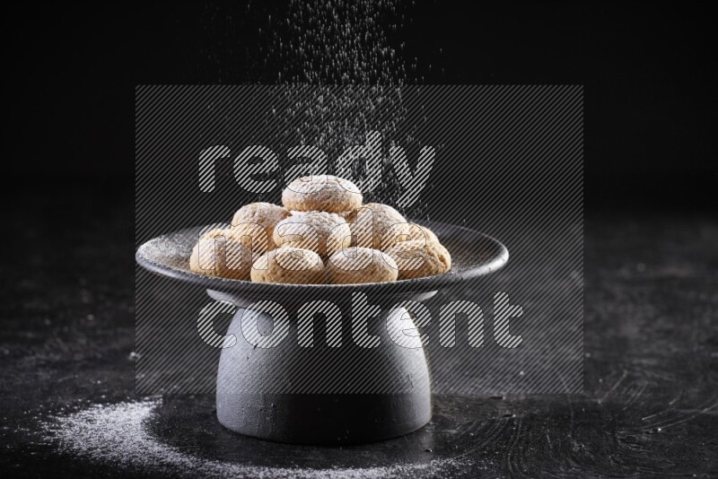 Kahk on a serving plate on a black background