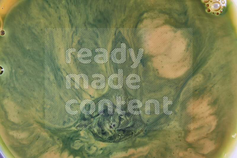 A close-up of abstract swirling patterns in orange and green