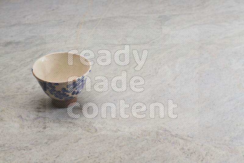 A multicolored pottery bowl on grey marble background