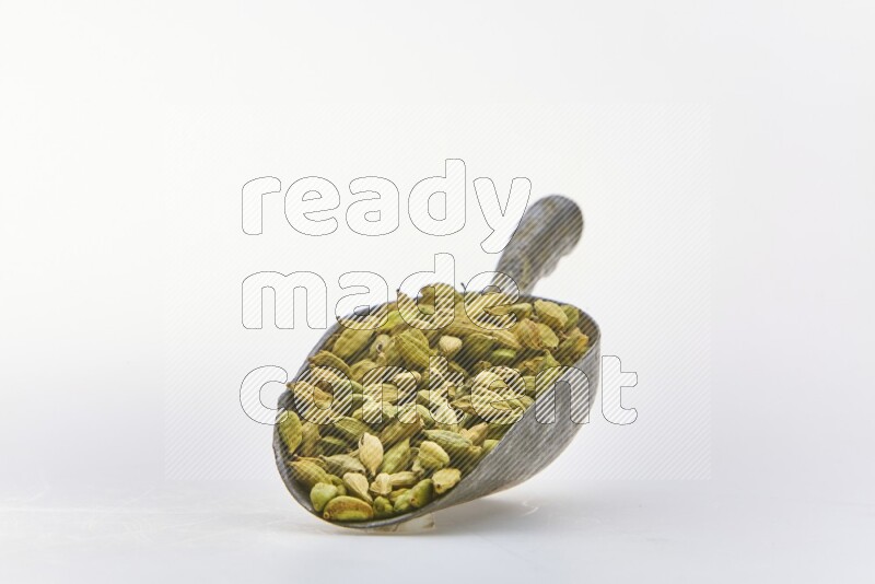 Cardamon in a shovel on white background
