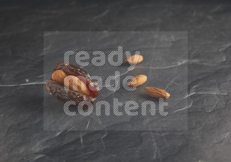 almond stuffed madjoul date on a black textured background