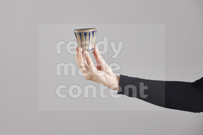 A woman in black abaya holding different pottery essentials in different positions