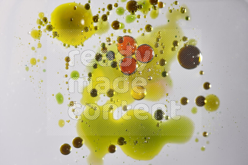 Close-ups of abstract red, green and yellow watercolor drops on oil Surface on white background