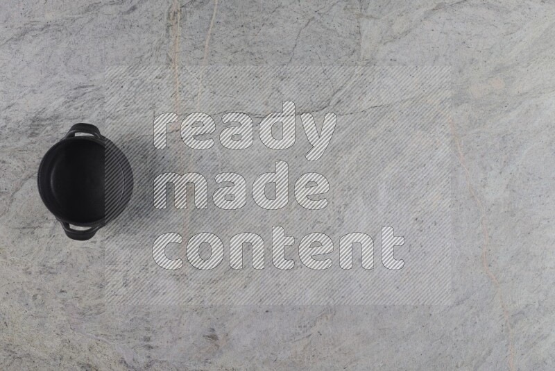 A black pottery bowl on grey marble background