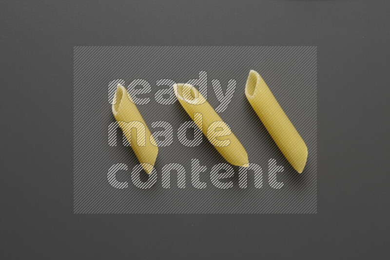 Penne pasta on grey background