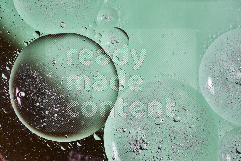 Close-ups of abstract oil bubbles on water surface in shades of black and green