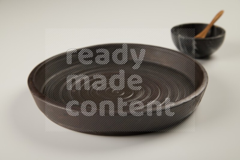 black pottery plate and black bowls on white background