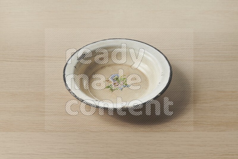 A vintage metal plate on light wooden background