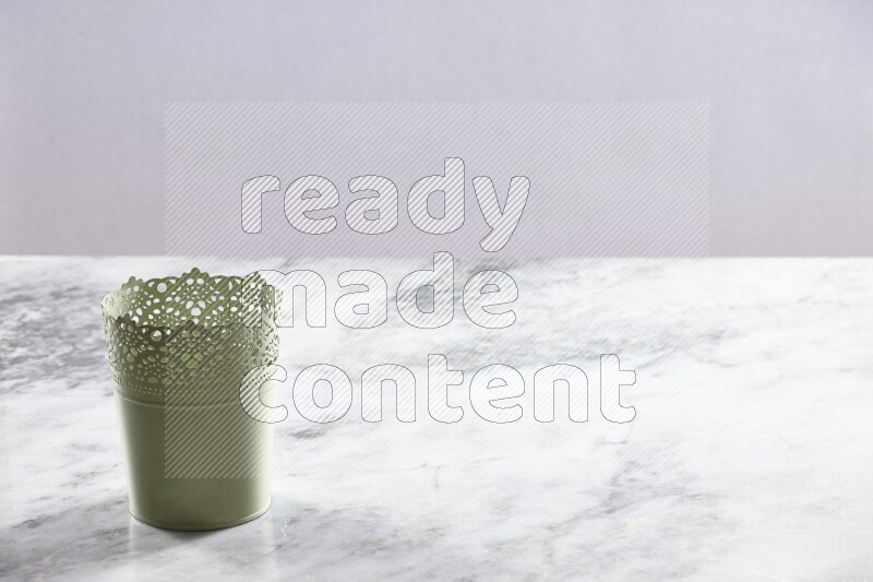 An empty green plant pot on grey marble background