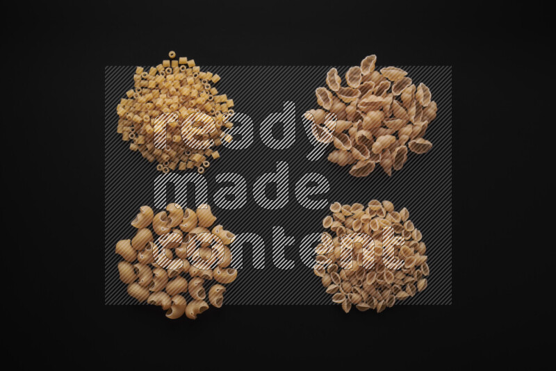 Different pasta types in bunches on black background