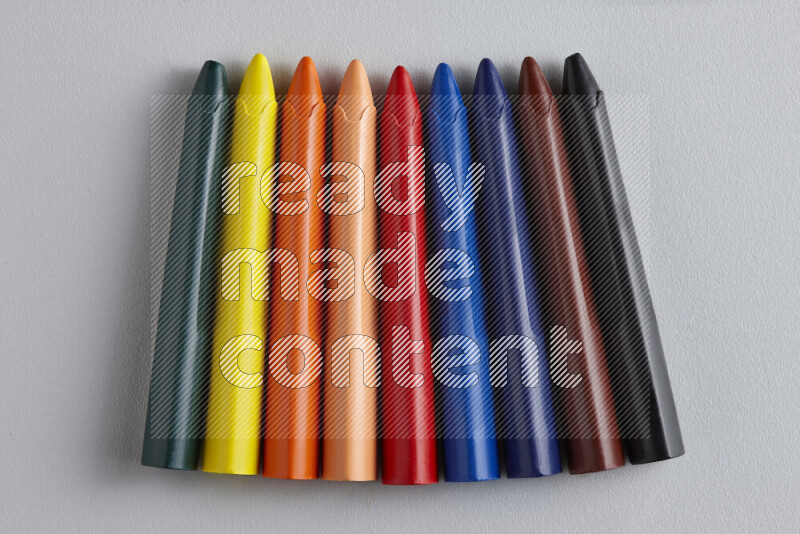 An arrangement of wax crayons in different colors on grey background