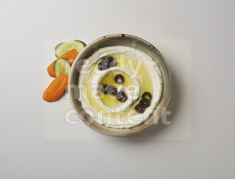 Lebnah garnished with sliced olives in a grey pottery plate on a white background