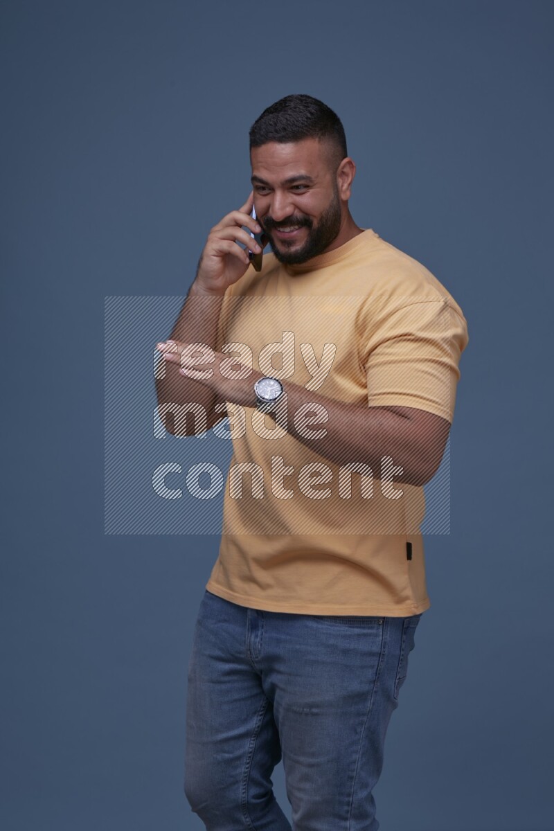 A man Calling on Blue Background wearing Orange T-shirt