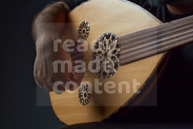 a hand intracting with a wooden brown Oud