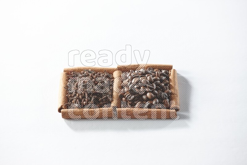 2 squares of cinnamon sticks full of coffee beans and cloves on white flooring