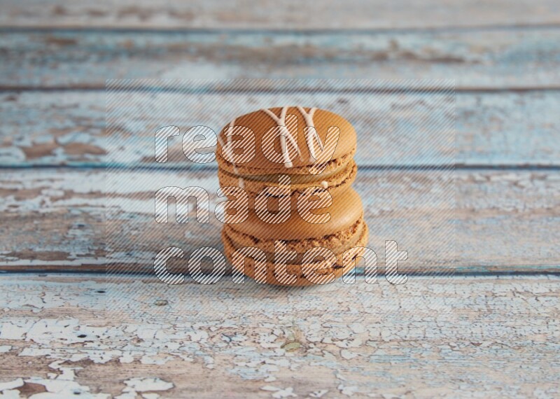 45º Shot of of two assorted Brown Irish Cream, and Brown Maple Taffy macarons  on light blue background