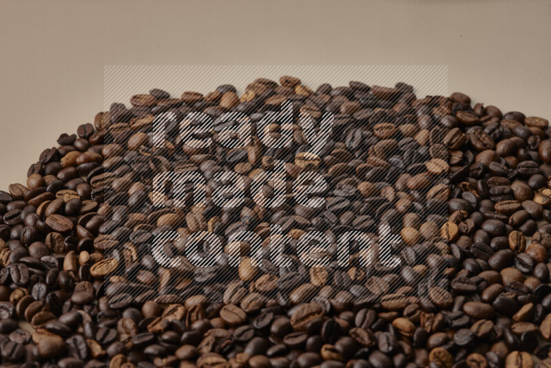 Roasted coffee beans on beige background