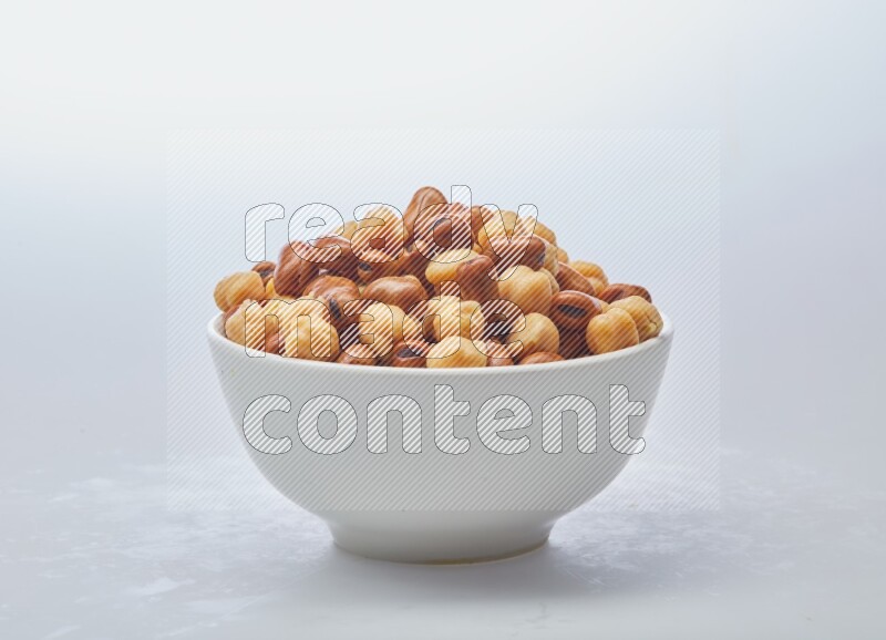 Close up shot of cooked fava beans (foul) & chickpeas on white background