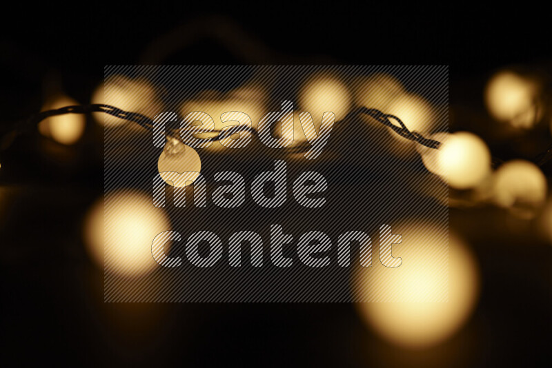 Light bulbs glowing against backdrop of golden bokeh