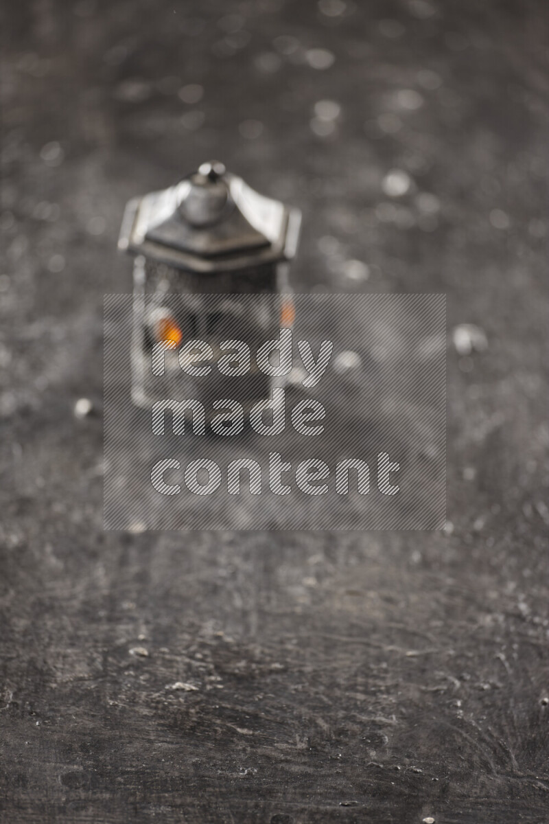A lantern placed on a textured black background