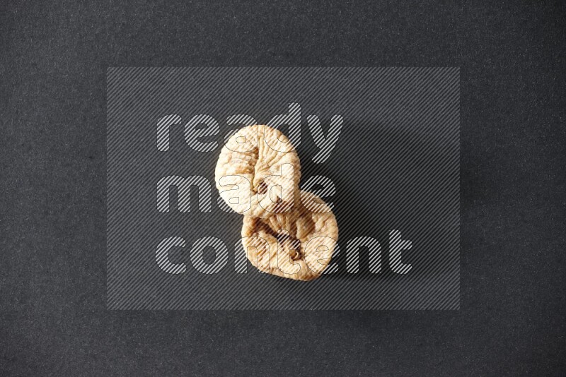 Two dried figs on a black background in different angles
