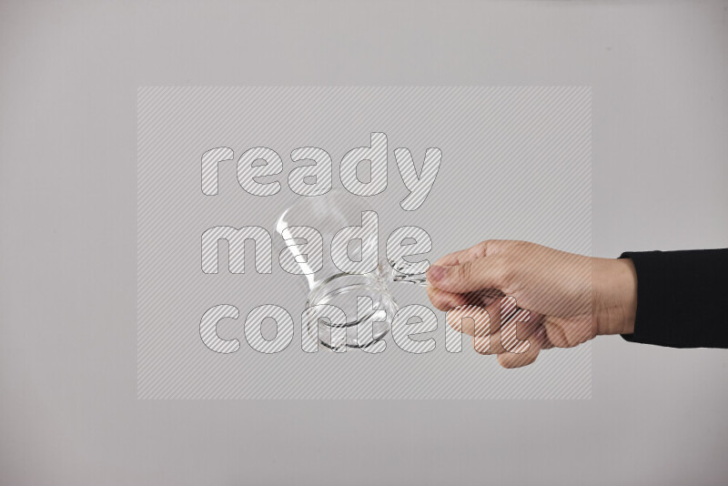 A woman in black abaya holding different glassware in different positions