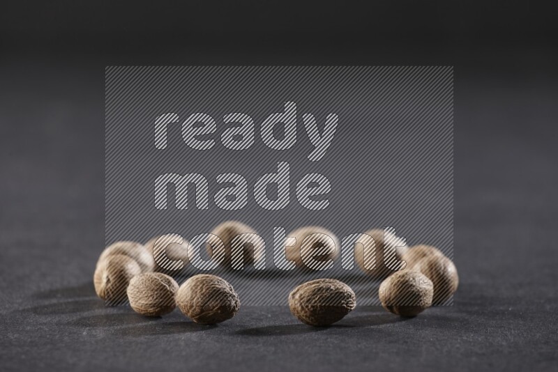 Nutmeg in a circle shape on a black flooring in different angles