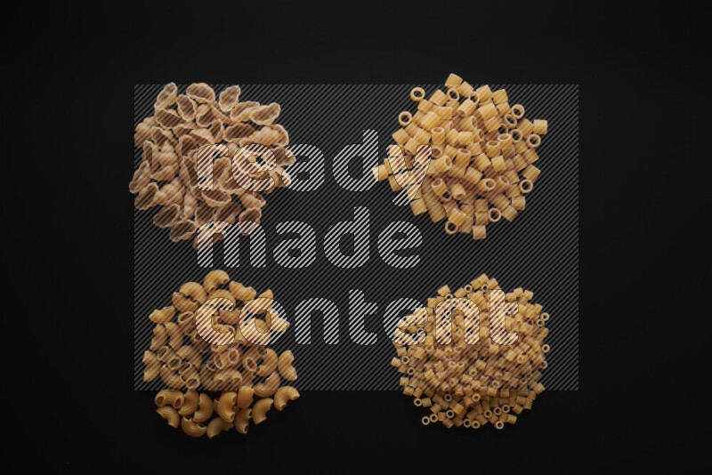 Different pasta types in bunches on black background