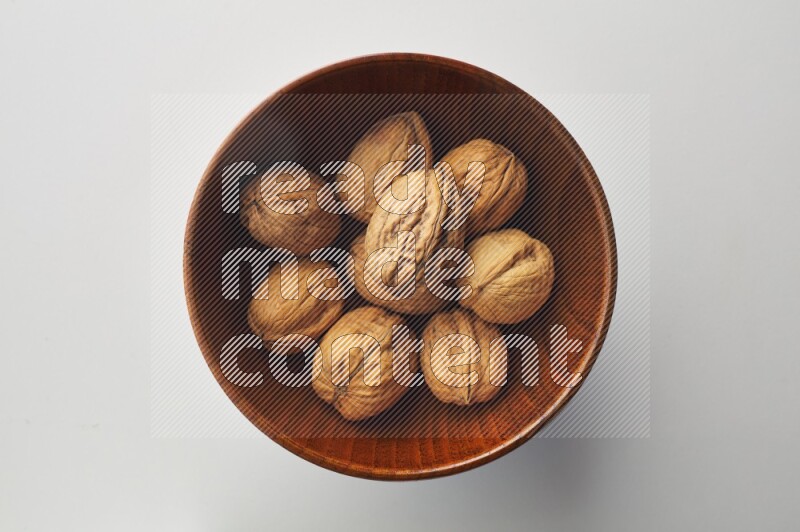 Top-view shot of walnut in a container on white background