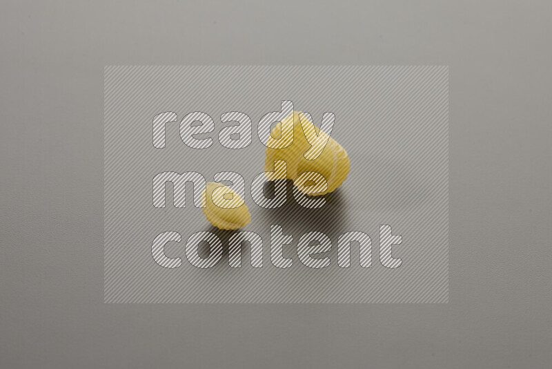Shells pasta with other types of pasta on grey background