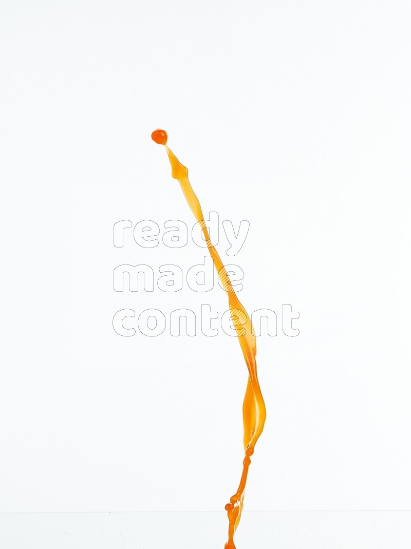 Orange liquid splash and drops on white background