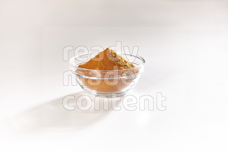 A glass bowl full of ground paprika powder on white background