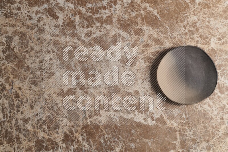 صحن فخاري متعدد الألوان على خلفية من الرخام البيج