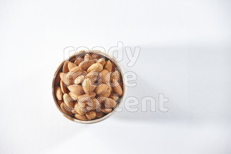 A beige ceramic bowl full of peeled almonds on a white background in different angles