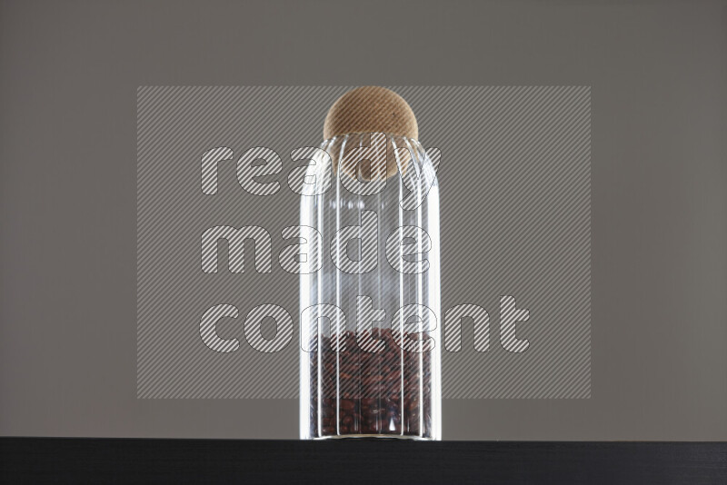 Red kidney beans in a glass jar on black background