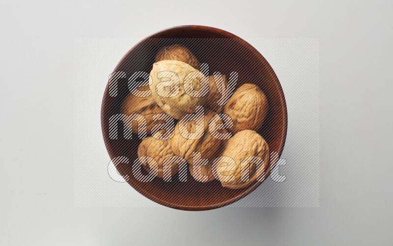 Top-view shot of walnut in a container on white background