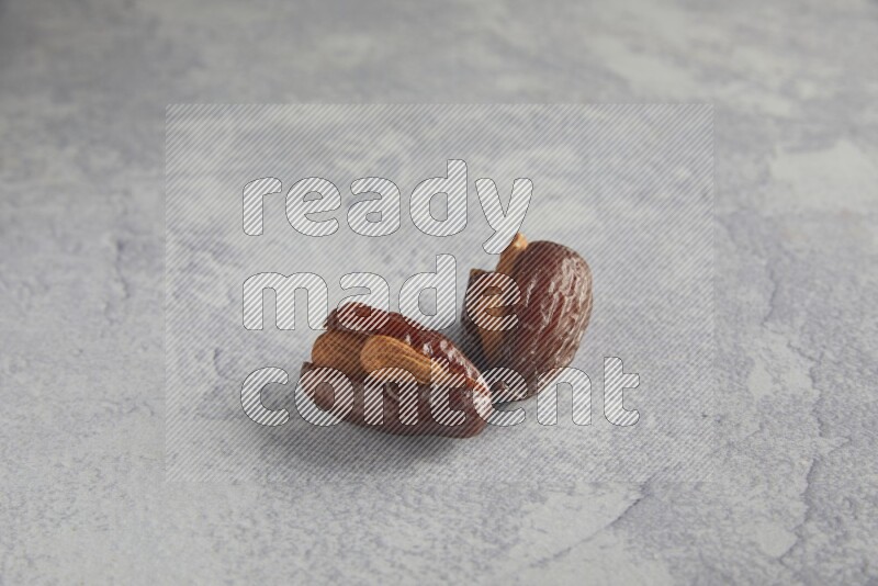 Two Almond stuffed date on a light grey background